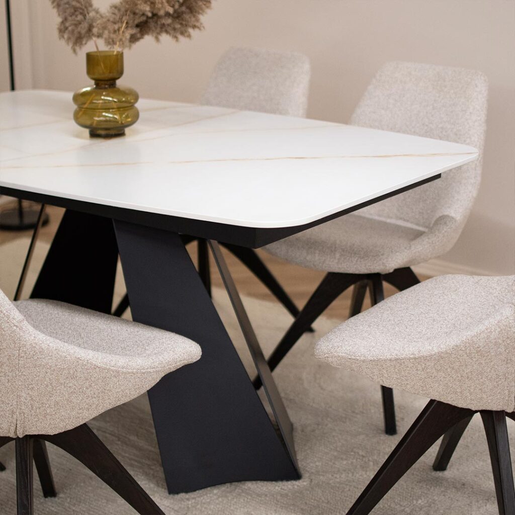 Трпезариски сет со маса со керамичка плотна и две црни метални ногарки.