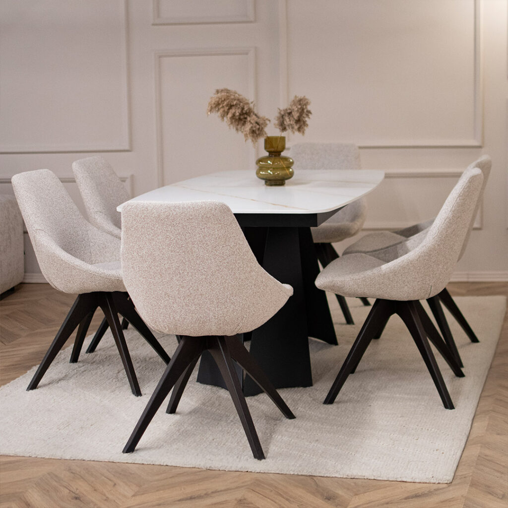 Трпезариски сет со маса со керамичка плотна и две црни метални ногарки, во комбинација со столици со светло крем мебел штоф.
