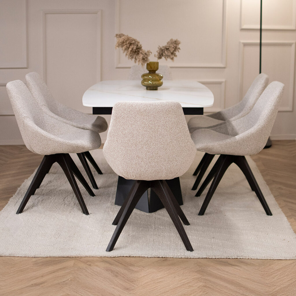 Трпезариски сет со маса со керамичка плотна и две црни метални ногарки, во комбинација со столици со светло крем мебел штоф.