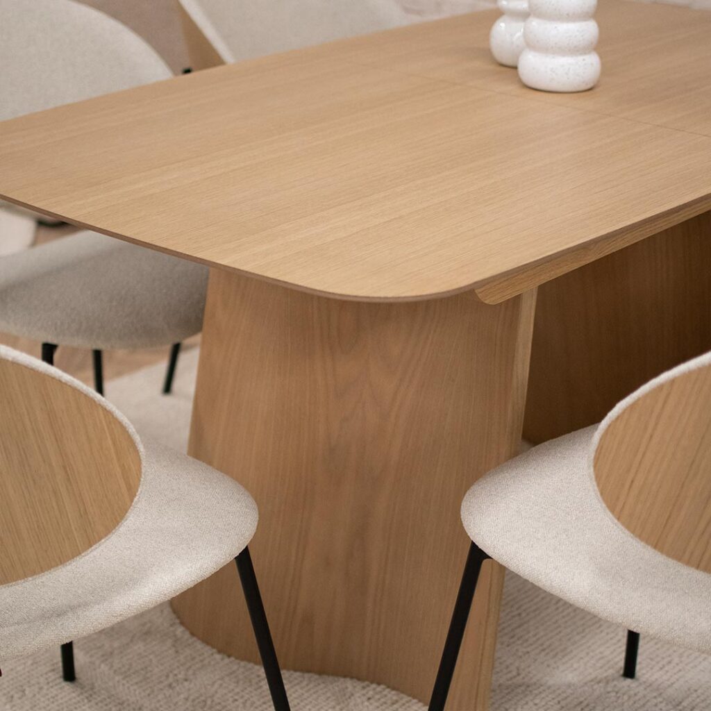 Трпезариска маса со заоблени агли од фурниран медијапан даб, со две неправилна форма ногарки од дрво даб.