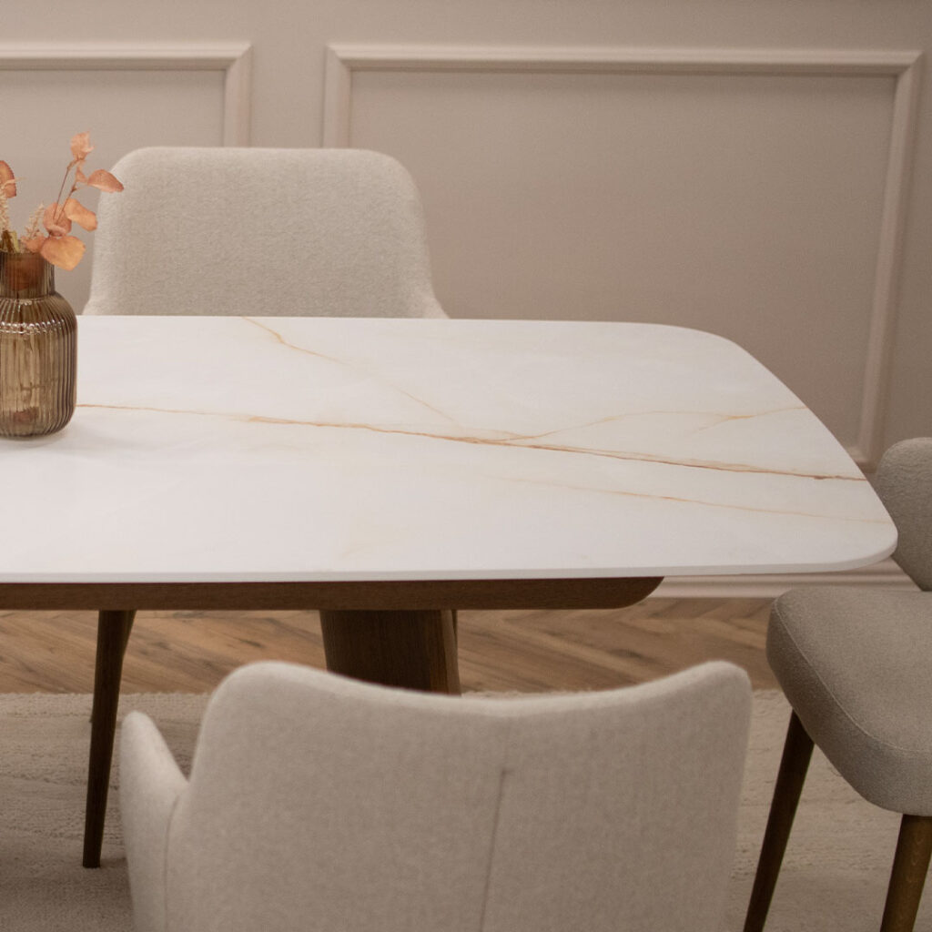 Плотна Cristallo Gold Cares Laminam на трпезариска маса со дрвени ногарки.