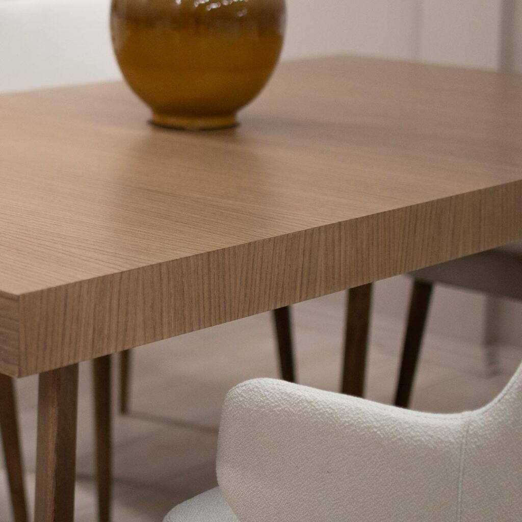 Трпезариски сет со правоаголна маса со опција за продолжување во кафеава даб нијанса и столици со раконаслон во бел мебел штоф.