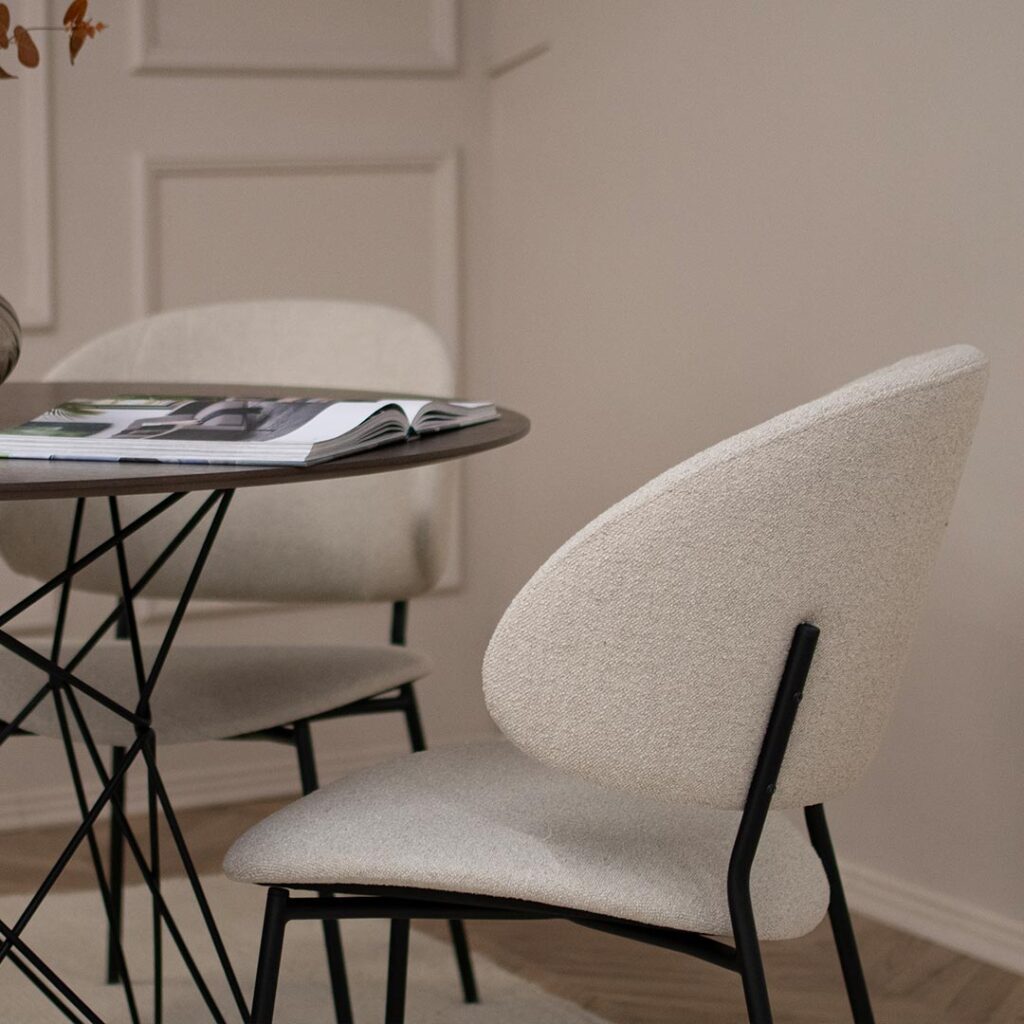 Трпезариски сет со кружна маса со плотна фурниран медијапан даб и испреплетени метални ногарки со 4 удобни столици во крем мебел штоф и црни метални ногарки.