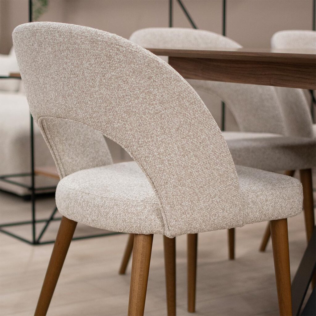 Трпезариска столица со кафеави бука дрво ногарки и светло крем мебел штоф, со отвор во грбот.