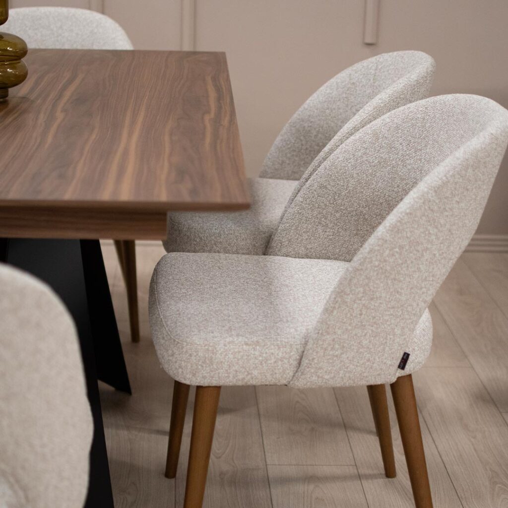 Трпезариска столица со кафеави бука дрво ногарки и светло крем мебел штоф, со отвор во грбот.