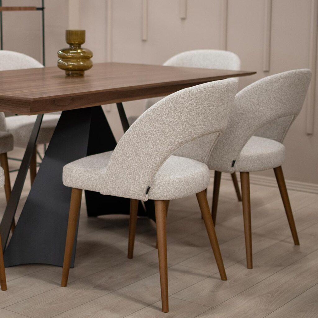 Трпезариска столица со кафеави бука дрво ногарки и светло крем мебел штоф, со отвор во грбот.