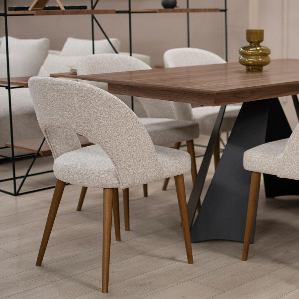 Трпезариска столица со кафеави бука дрво ногарки и светло крем мебел штоф, со отвор во грбот.