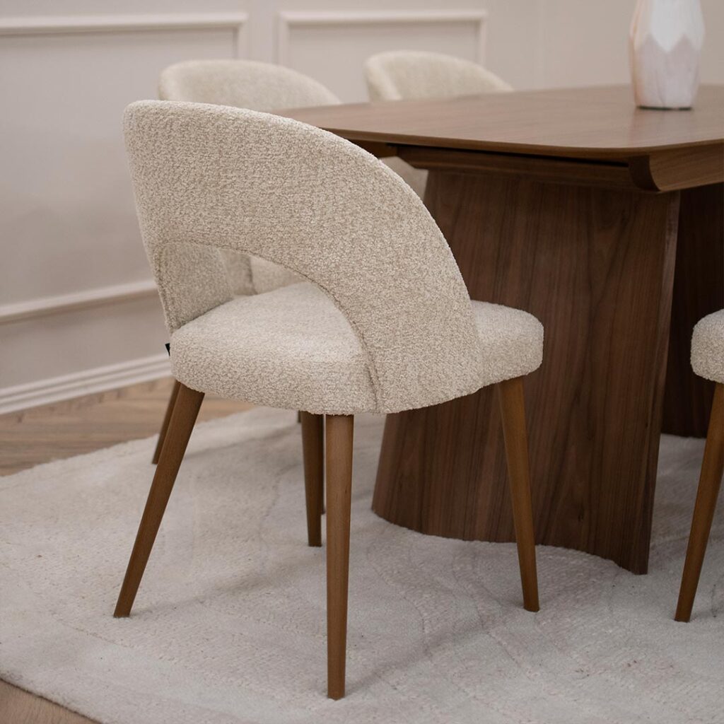 Tрпезарискa столицa со кафеави бука ногарки и мебел штоф букле во крем боја.