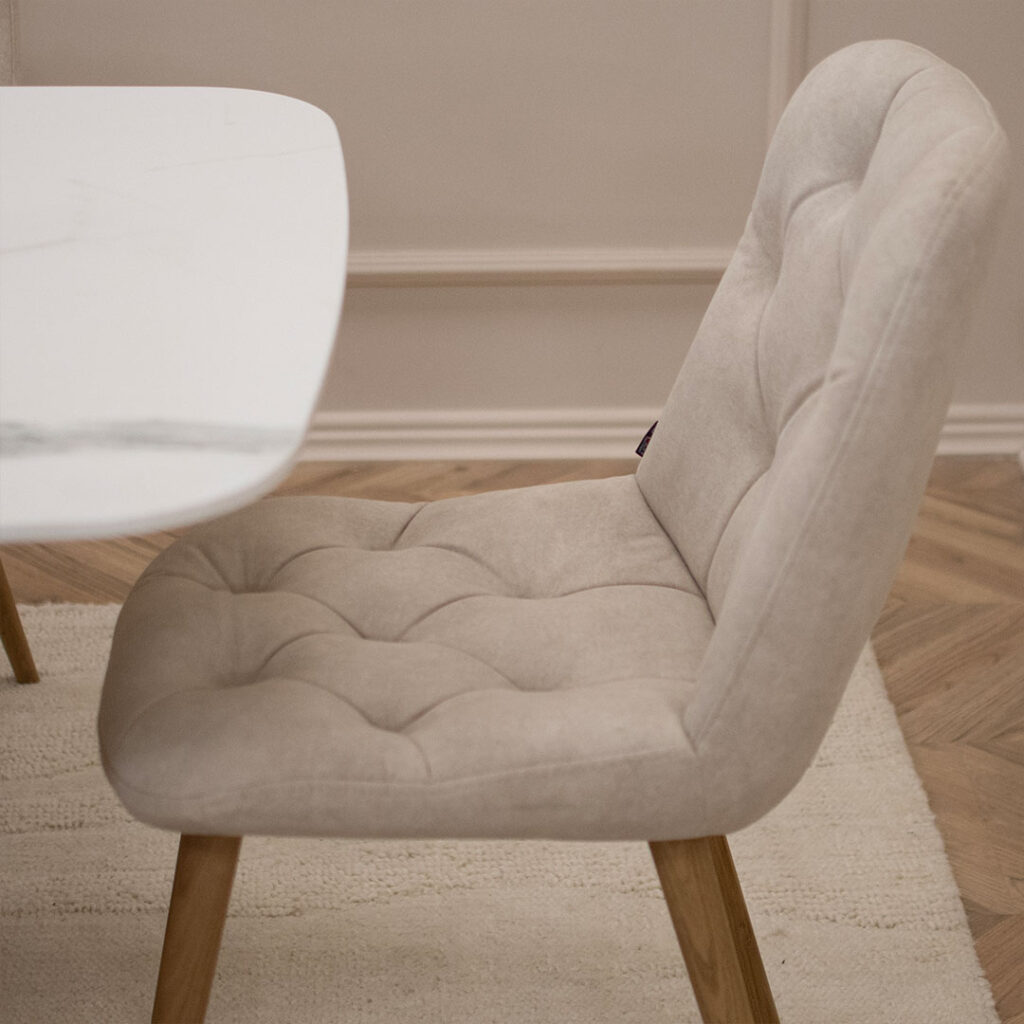 Трпезариска столица Клои со даб ногарки и мебел штоф велвет во крем боја.