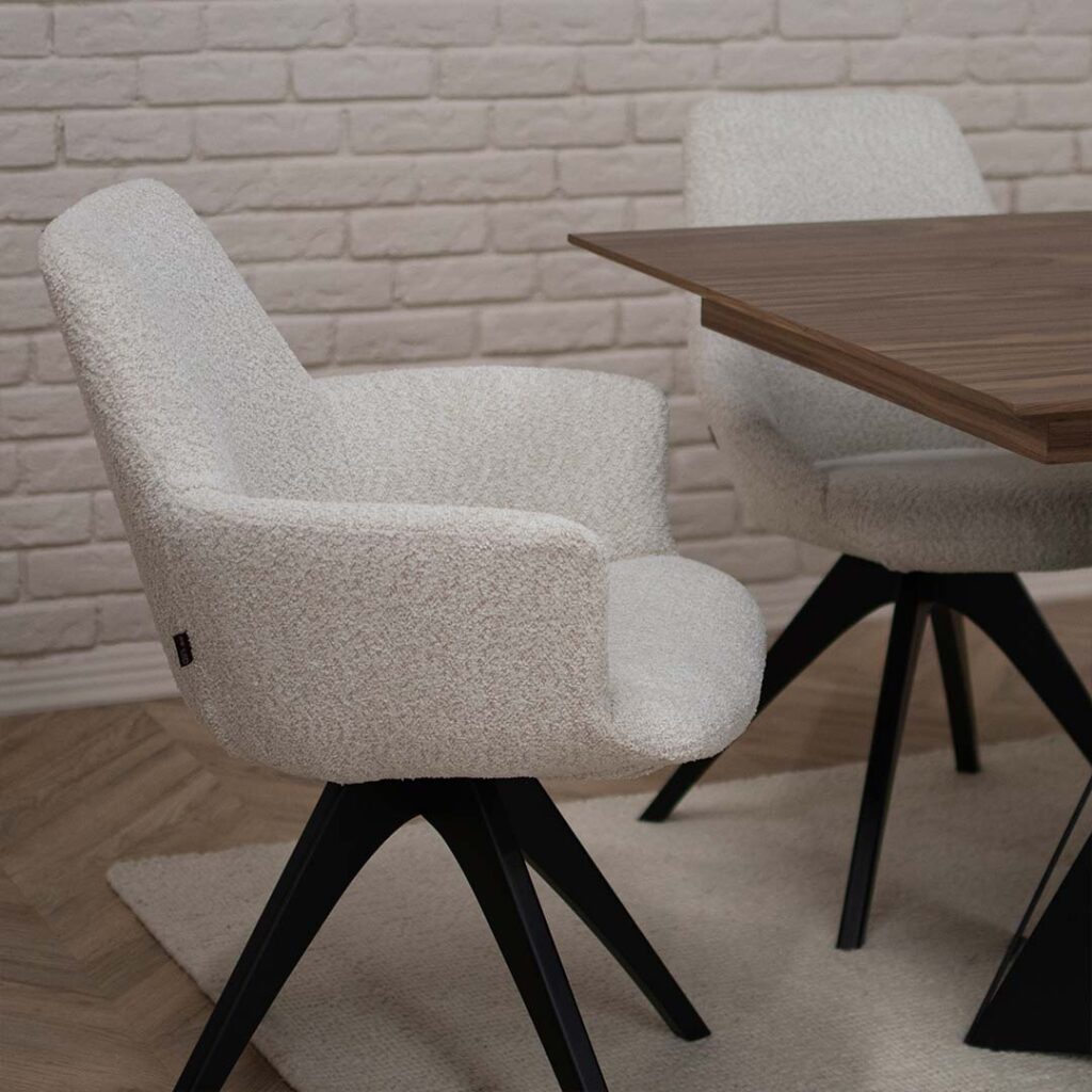 трпезариска столица со раконаслон во крем букле со црни дрвени ногарки на трпезариска маса со плотна орев.