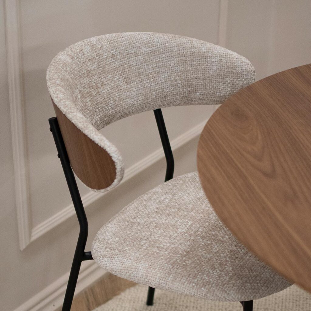 Трпезариска столица Оасис со фурниран грб од орев во комбинација со светло крем мебел штоф и црни метални ногарки.