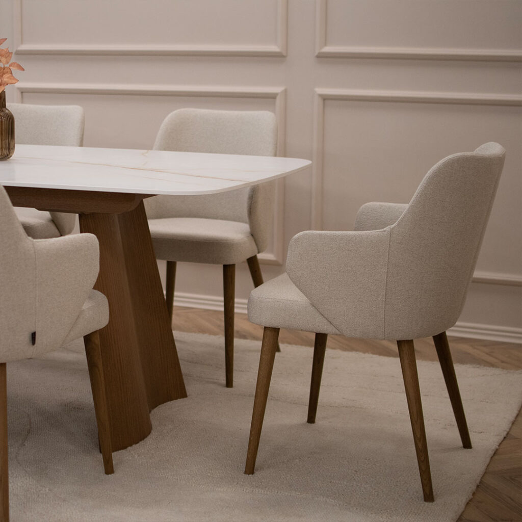 Трпезариски столици со раконаслон во крем мебел штоф и дрвени даб ногарки во кафеава боја.