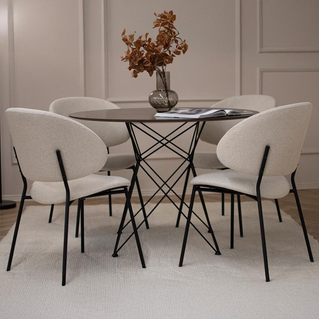 Трпезариски сет со кружна маса со плотна фурниран медијапан даб и испреплетени метални ногарки со 4 удобни столици во крем мебел штоф и црни метални ногарки.
