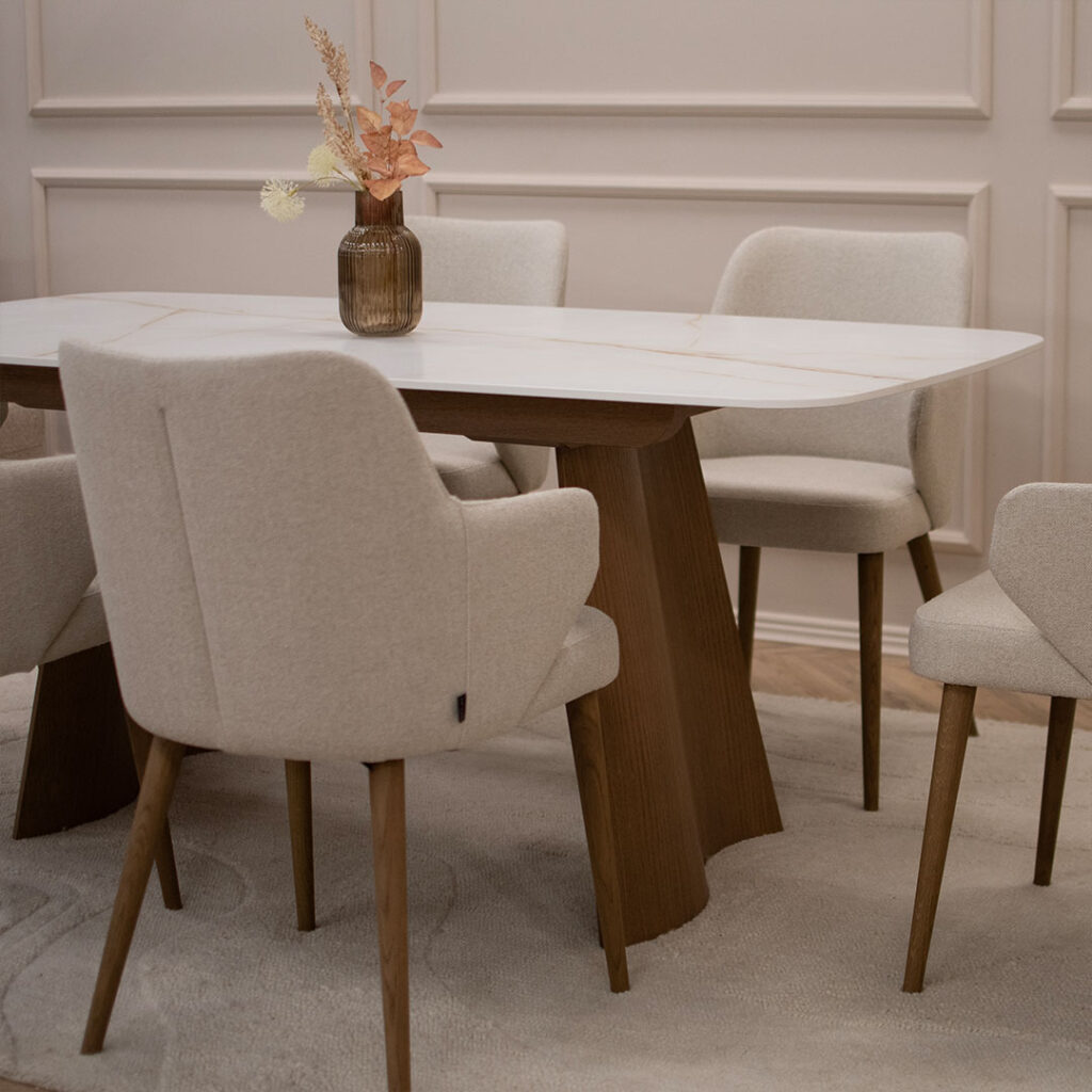 Трпезриска маса Сфера со плотна Laminam и ногарки од дрво даб, во комбинација со столици со раконаслон во крем мебел штоф.