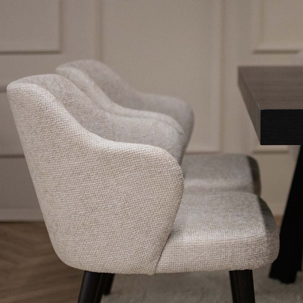 Трпезариска столица со раконаслон, во светко крем мебел штоф и црни бука ногарки.