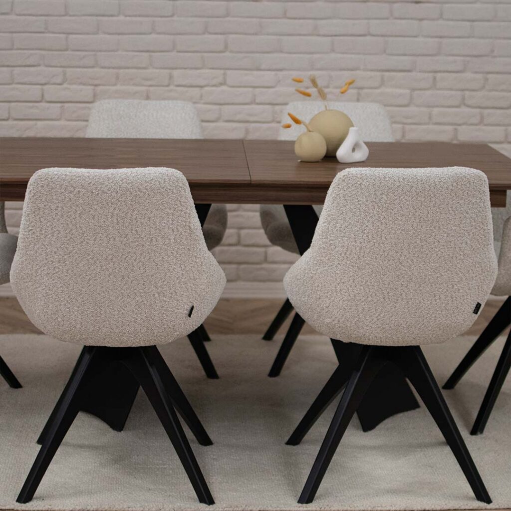 Две трпезариски столици во крем букле со црни дрвени ногарки на трпезариска маса со плотна орев.