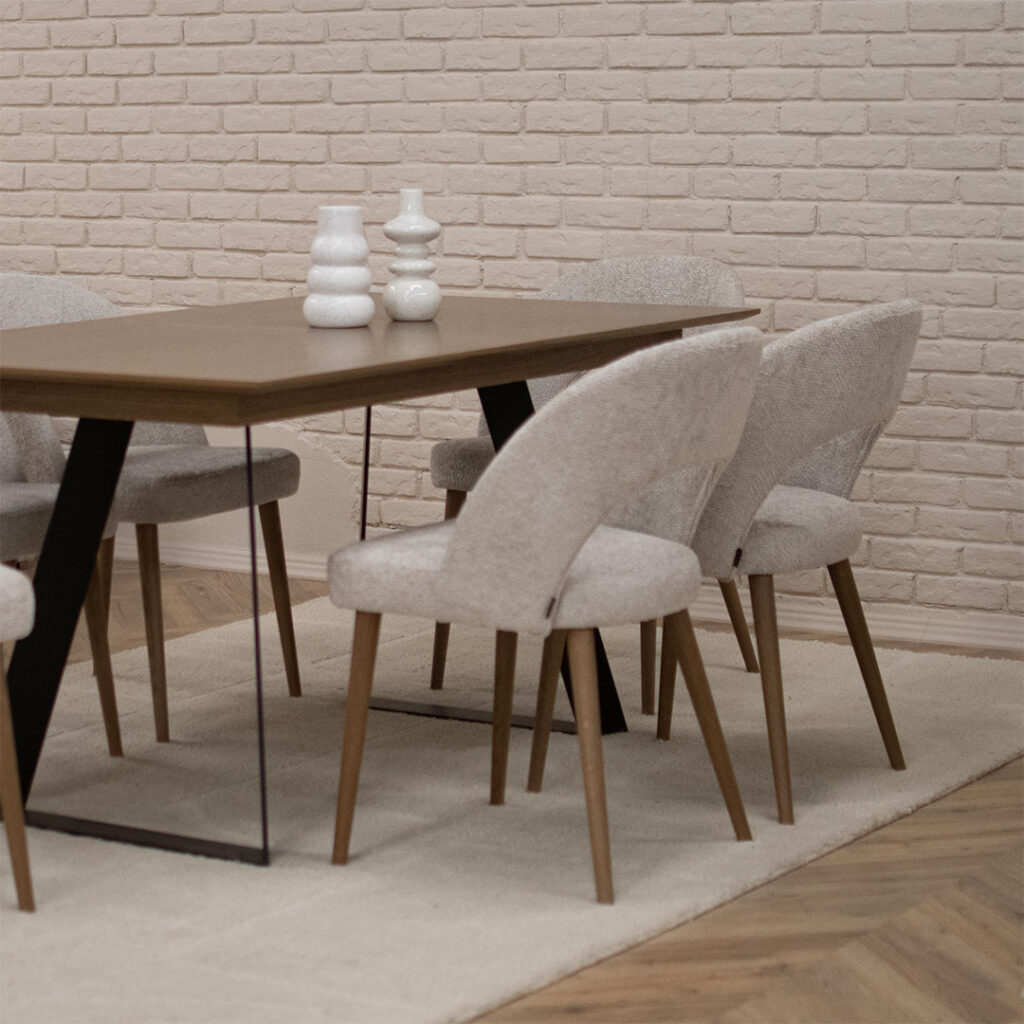 Трпезариска маса со плотна даб и две метални ногарки во П форма, со столици со даб ногарки и беж мебел штоф.