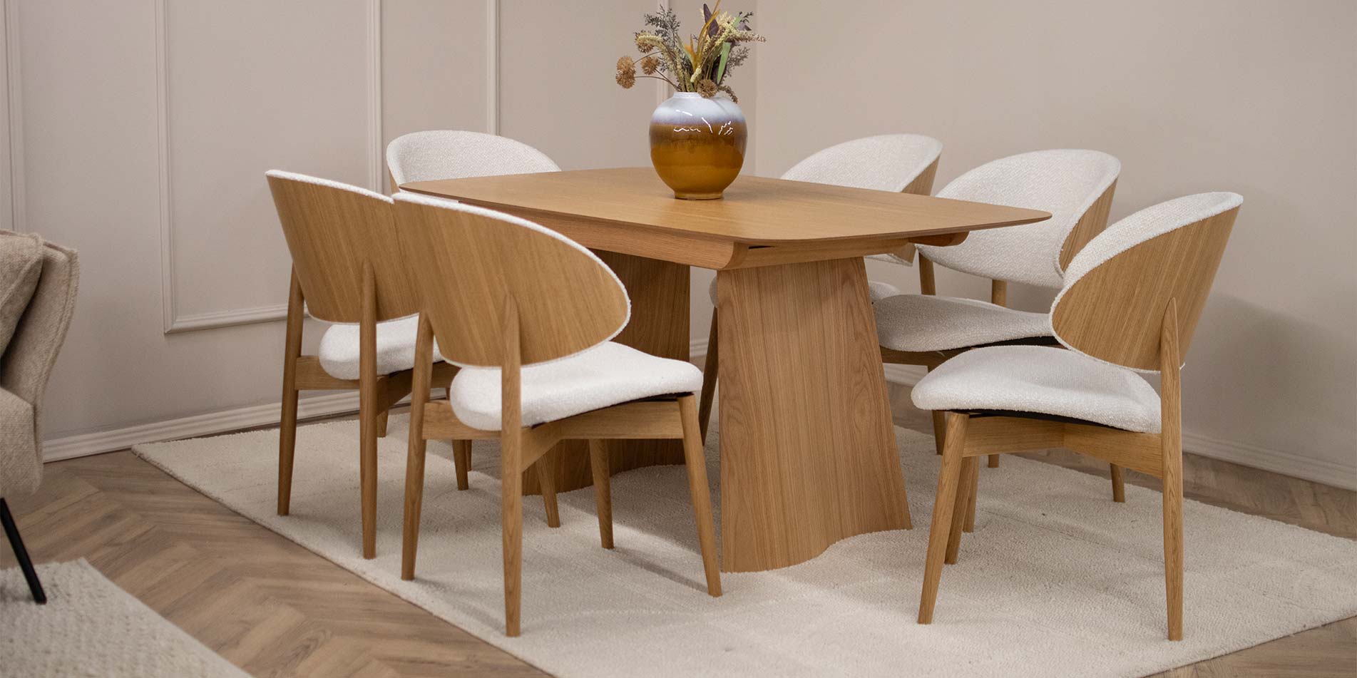 Трпезариски сет со трпезариска маса од даб натур во комбинација со столици со даб ногарки и грб од фурнир од даб, во комбинација со бел мебел штоф.