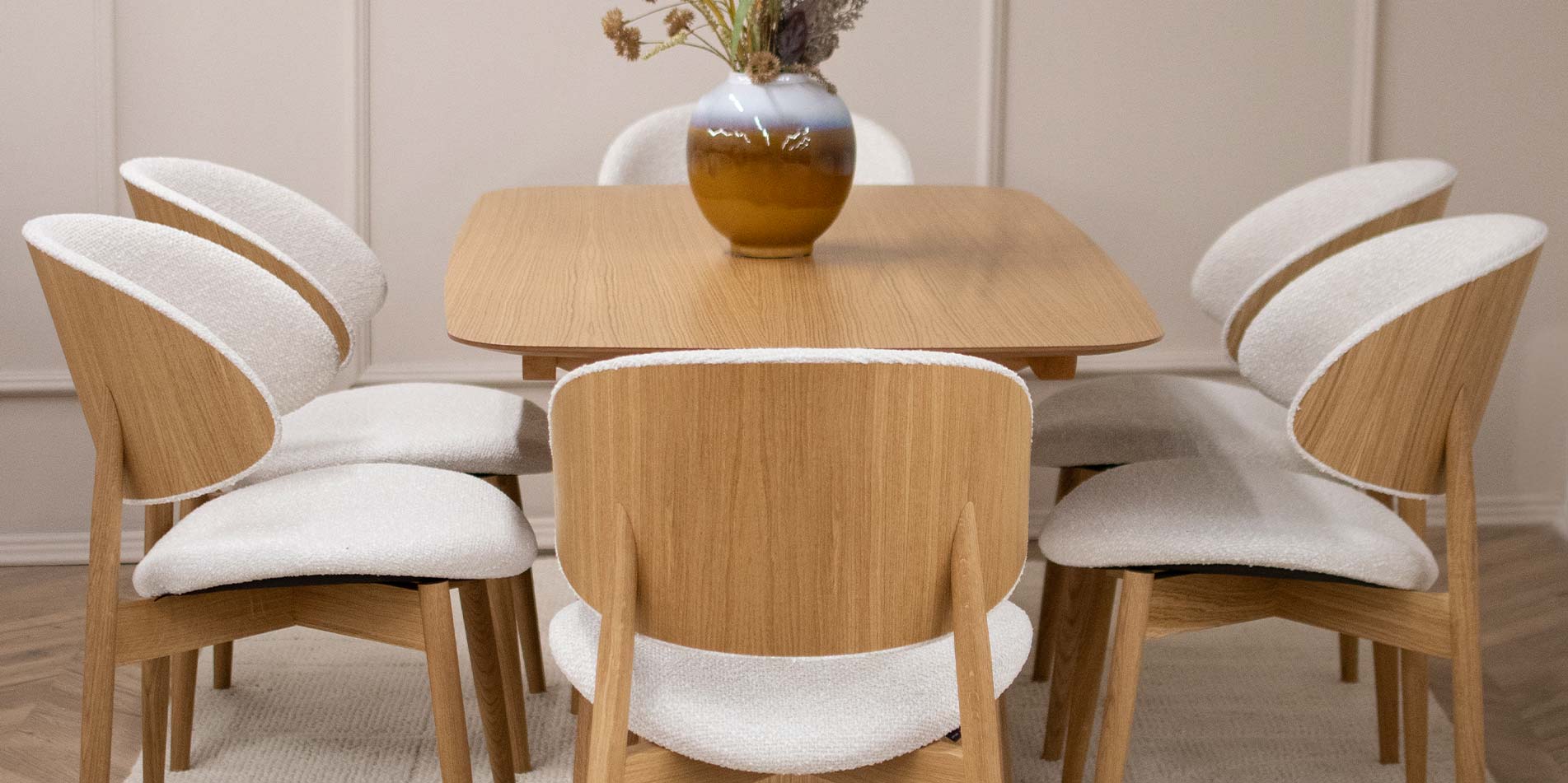 Трпезариски сет со трпезариска маса од даб натур во комбинација со столици со даб ногарки и грб од фурнир од даб, во комбинација со бел мебел штоф.