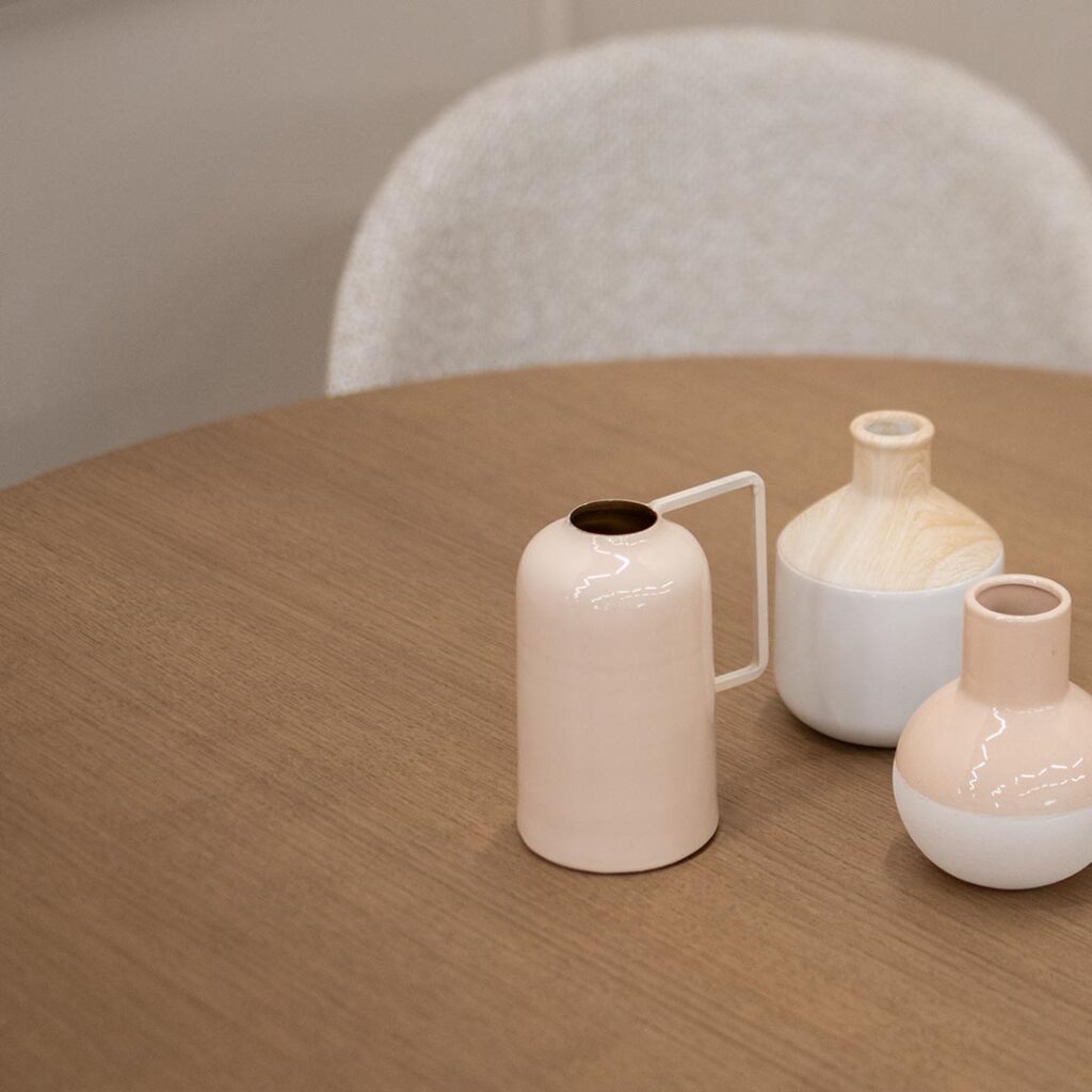 Мала кружна маса со плотна дурниран медијапан даб во кафеава нијанса и црни испреплетени метални ногарки.