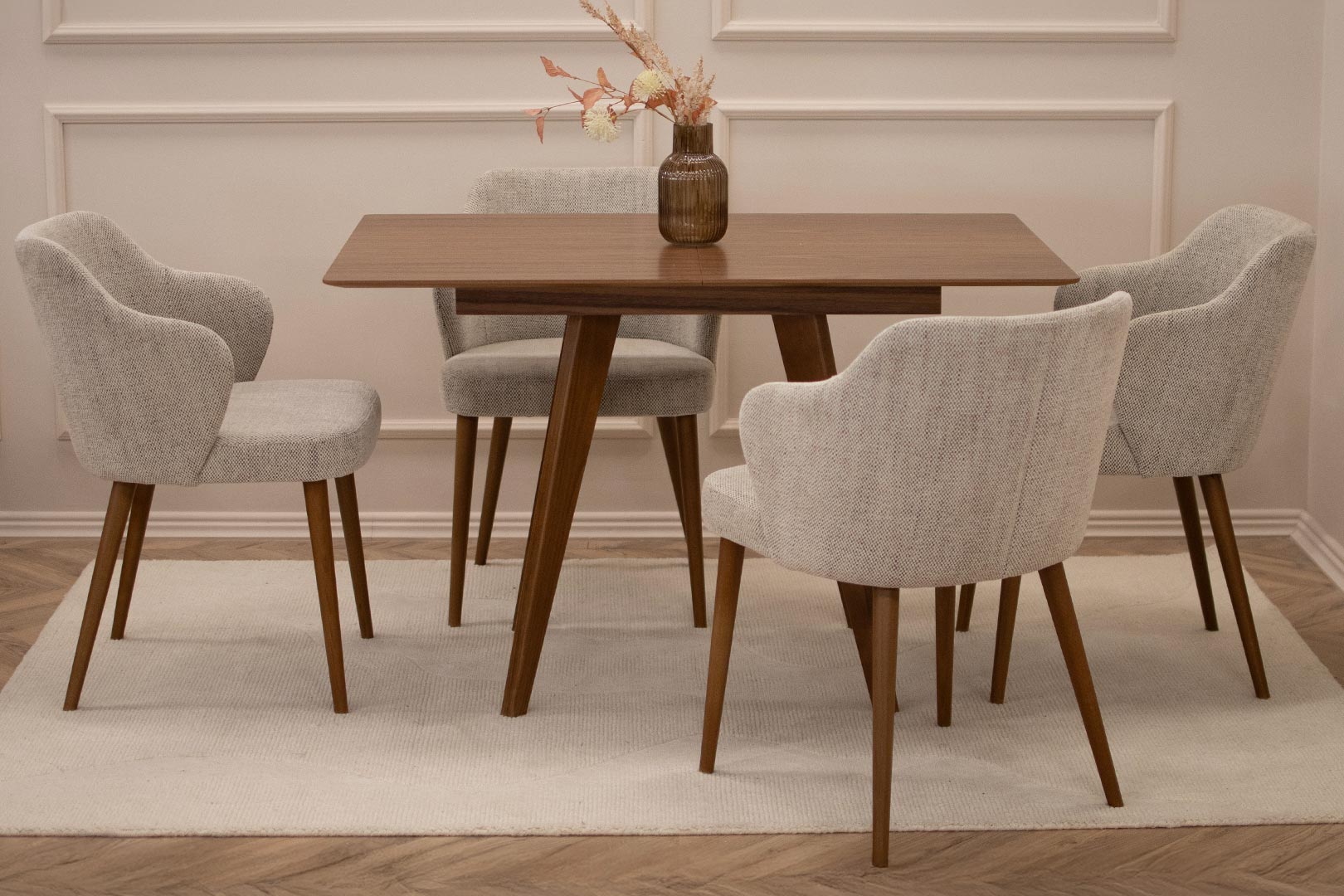 Трпезариски сет со мала правоаголна маса со плотна фурниран медијапан орев со опција за прдолжување од +35 см, во комбинација со столици со раконаслон во светло крем мебел штоф и бука ногарки во кафеава боја.