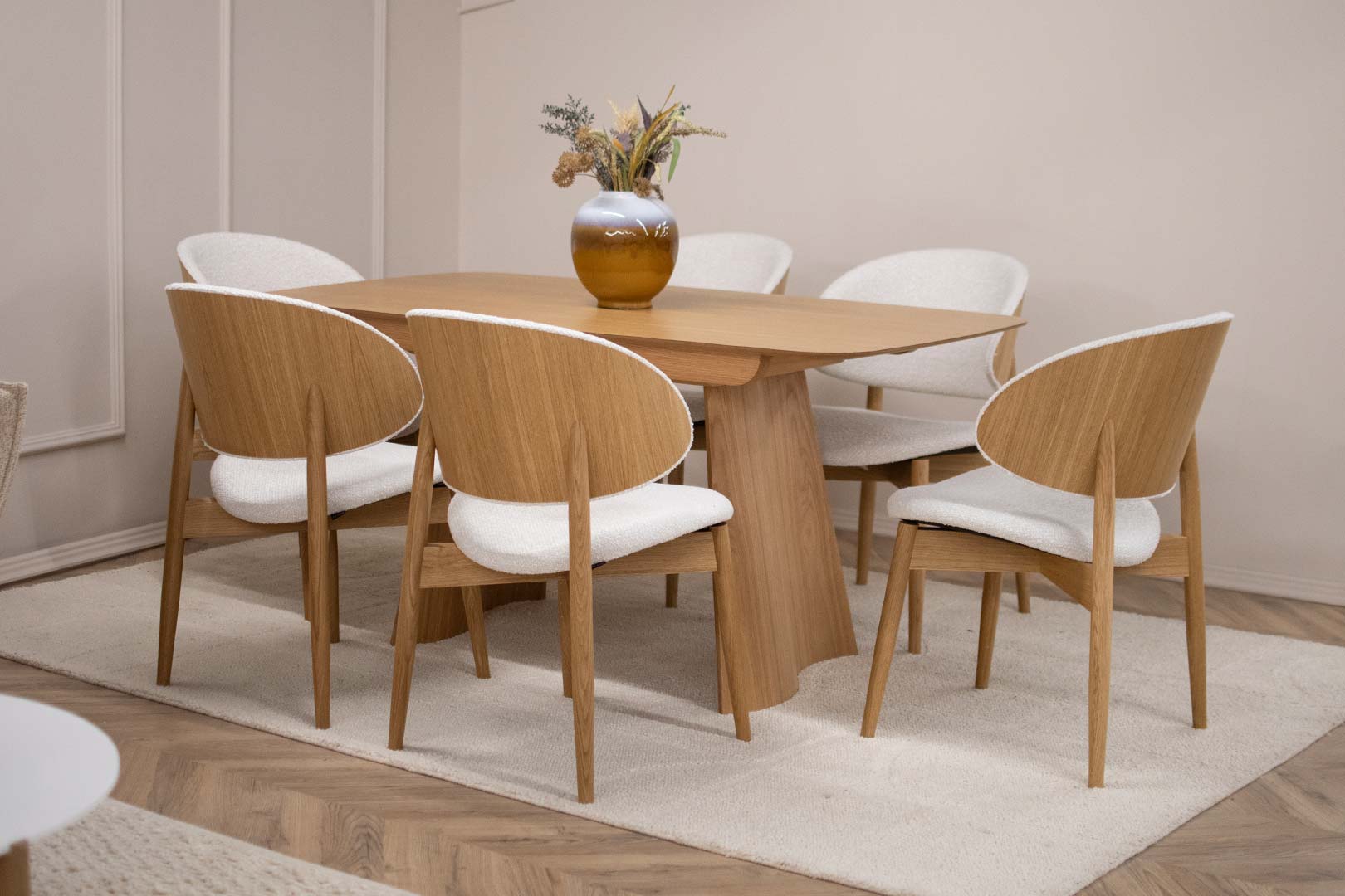 Трпезариски сет со маса од дрво даб во натур боја во комбинација со столици со даб ногарки и грб од фурнир даб со бел мебел штоф.