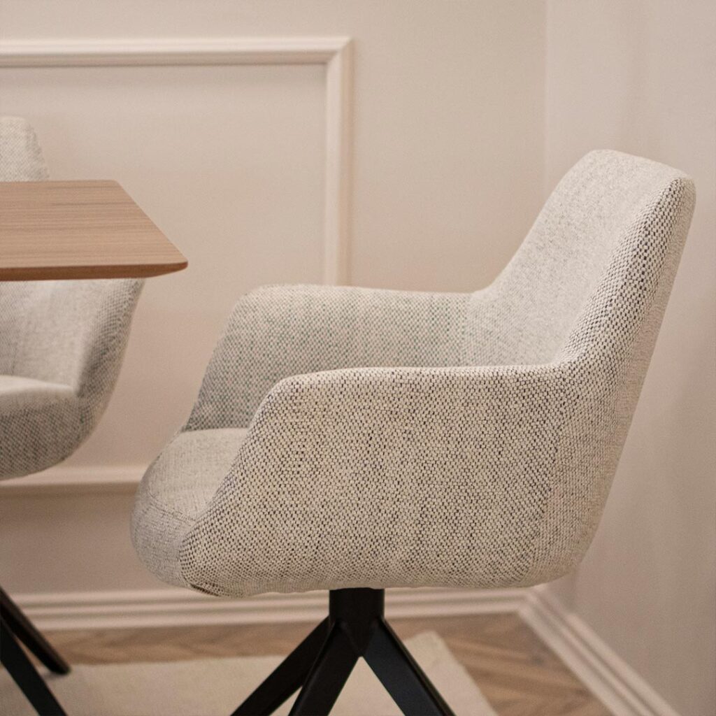 Трпезариска столица со раконаслон во крем мебел штоф и црни метални ногарки.