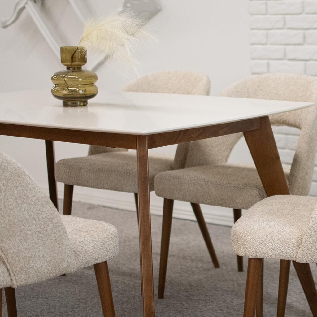 Правоаголна трпезариска маса со продолжеток , со бела мат плотна и бука ногарки во кафаева боја.