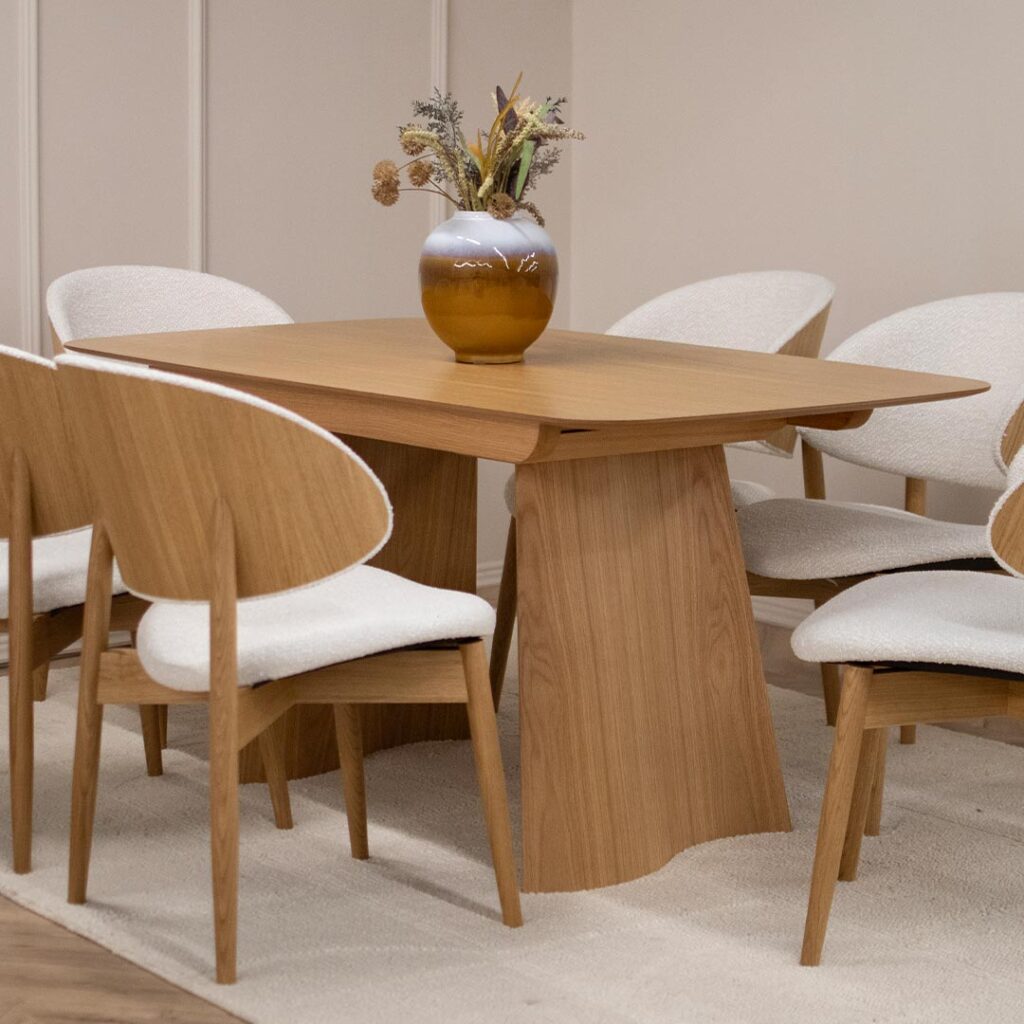 Трпезариска маса од дрво даб во натур боја, со две неправилна форма ногарки.