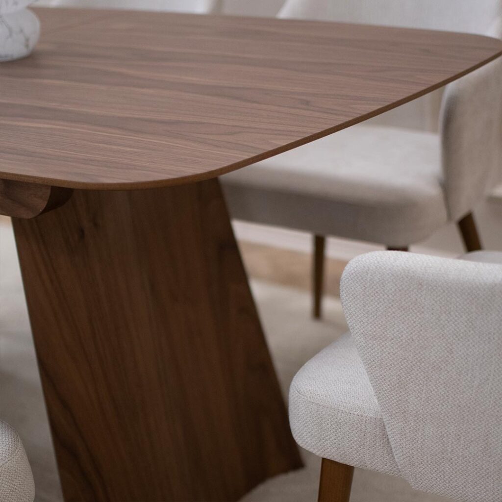 Трпезариски сет со маса со заоблена плотна орев и две неправилна форма ногарки.