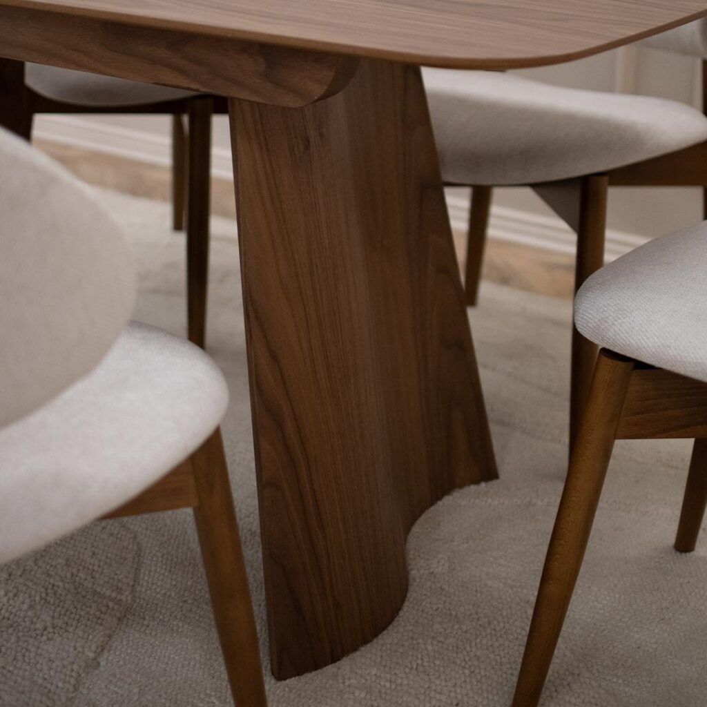 Трпезариска маса со две неправилна форма ногарки од орев и овална плотна од орев.