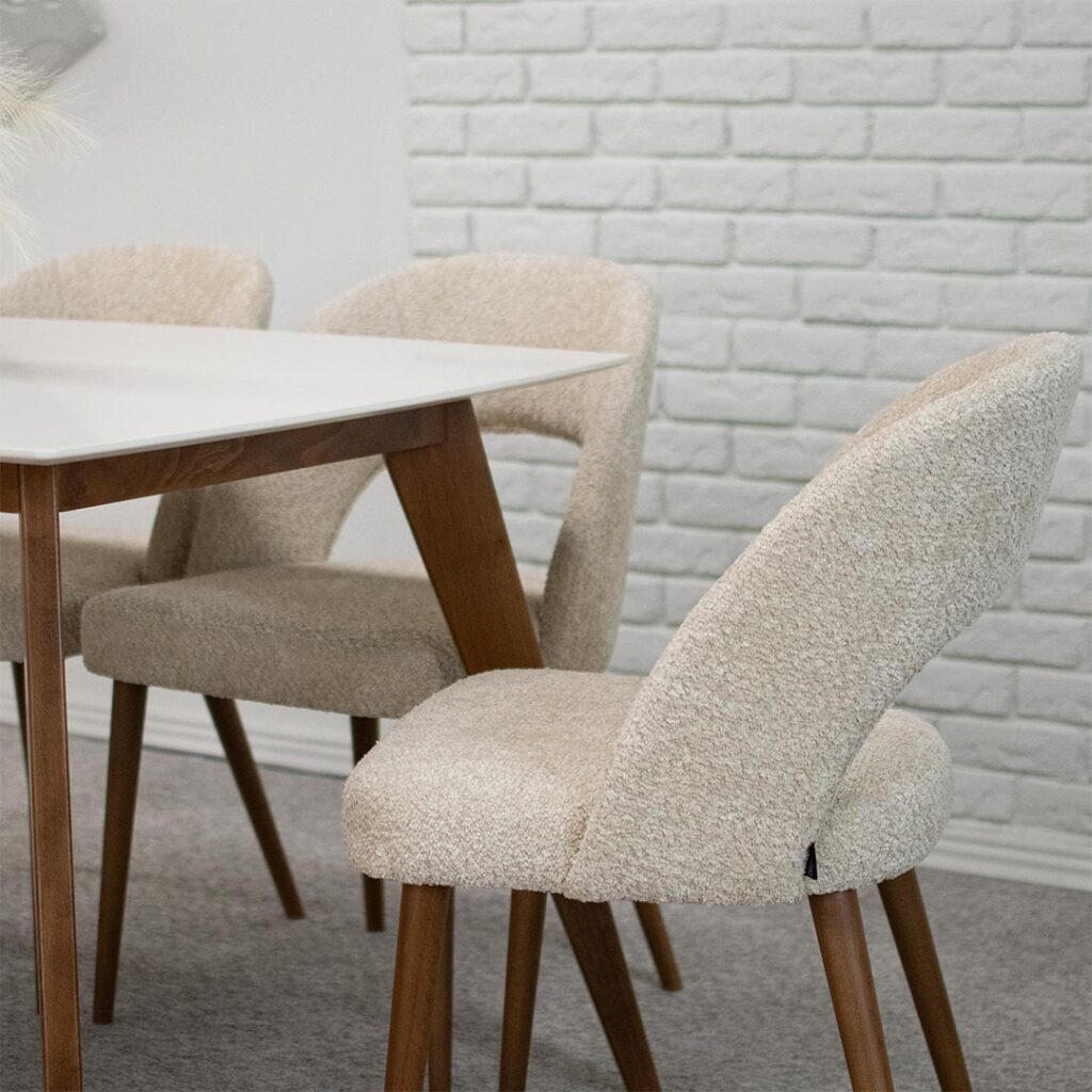 Трпезариски столици со отвор во грбот, изработени во крем букле и бука кафеава боја ногарки.