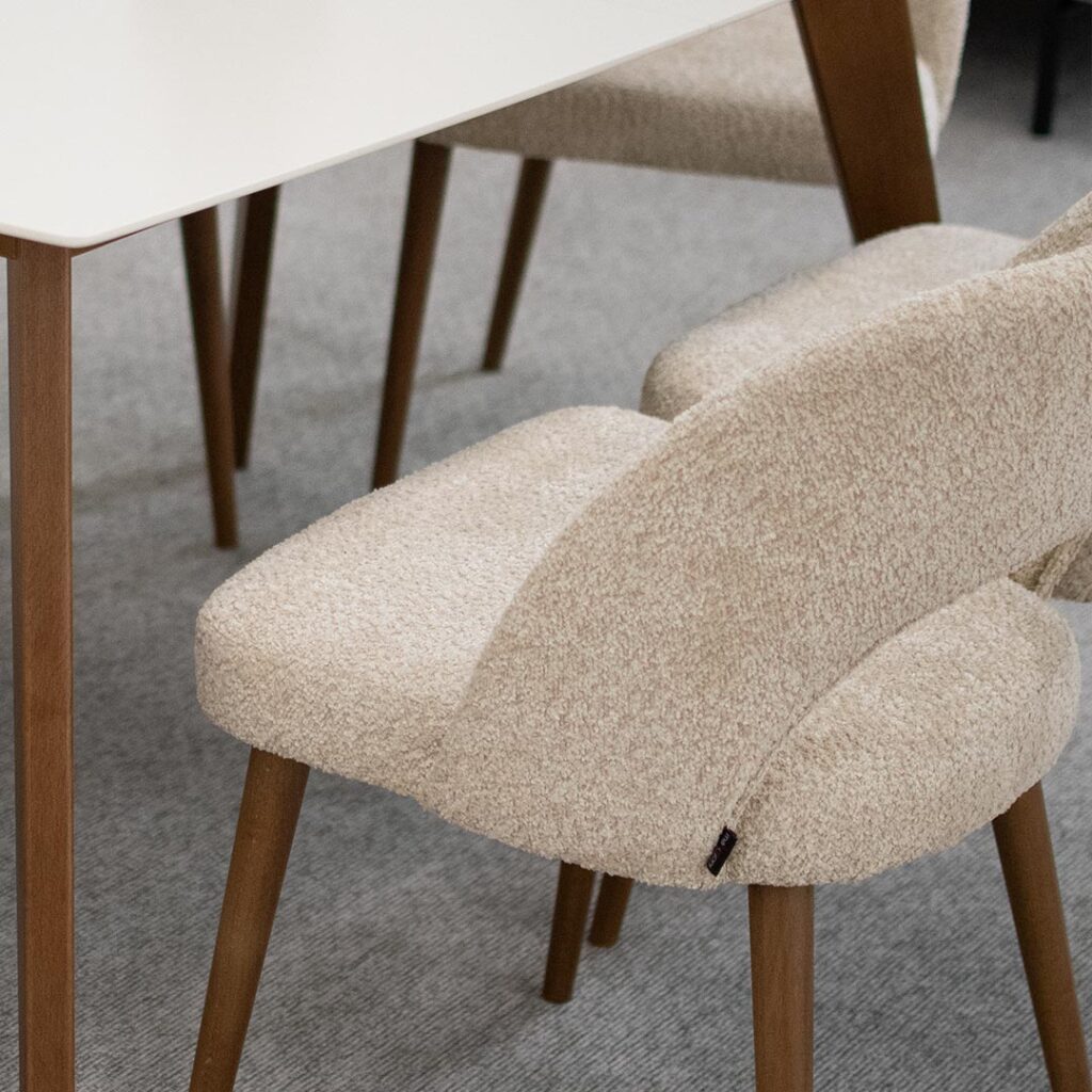 Трпезариски столици со отвор во грбот, изработени во крем букле и бука кафеава боја ногарки.