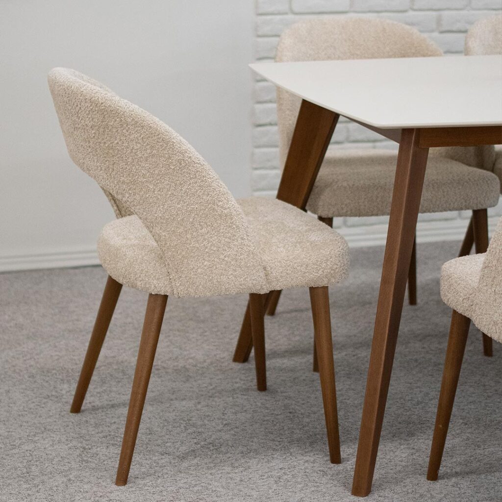 Трпезариски столици со отвор во грбот, изработени во крем букле и бука кафеава боја ногарки.