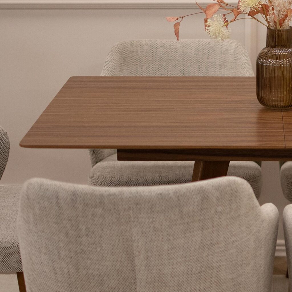 Трпезариски сет со мала правоаголна маса со плотна фурниран медијапан орев со опција за прдолжување од +35 см, во комбинација со столици со раконаслон во светло крем мебел штоф и бука ногарки во кафеава боја.