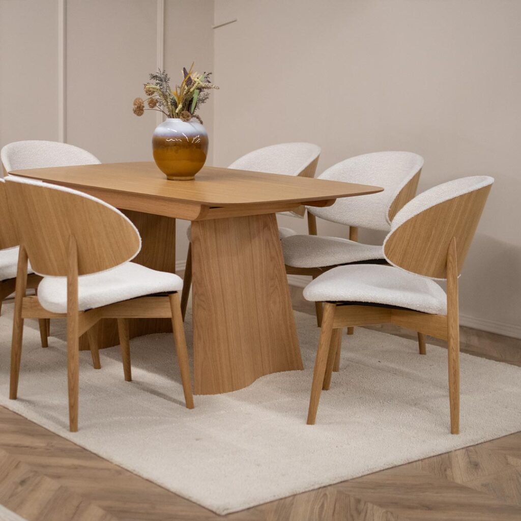 Трпезариска маса од дрво даб во натур боја, со две неправилна форма ногарки.