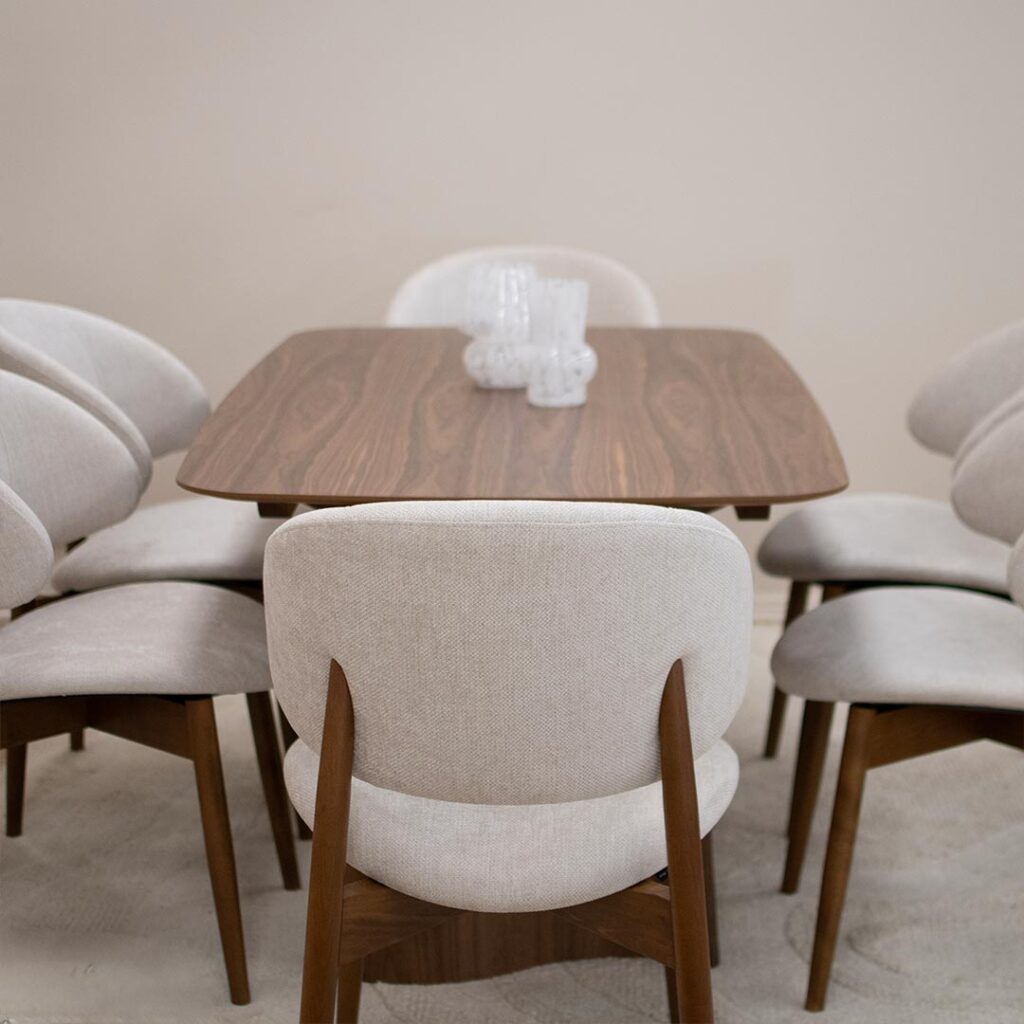 Трпезариска маса со две неправилна форма ногарки од орев и овална плотна од орев.