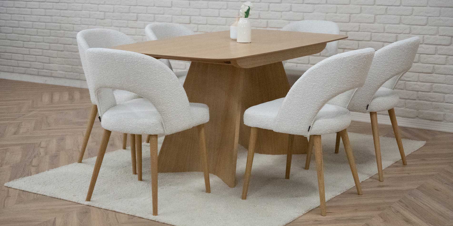 Trpezariska masa od dab natur, so dve nepravilna forma nogarki, so beli trpezariski stolici.