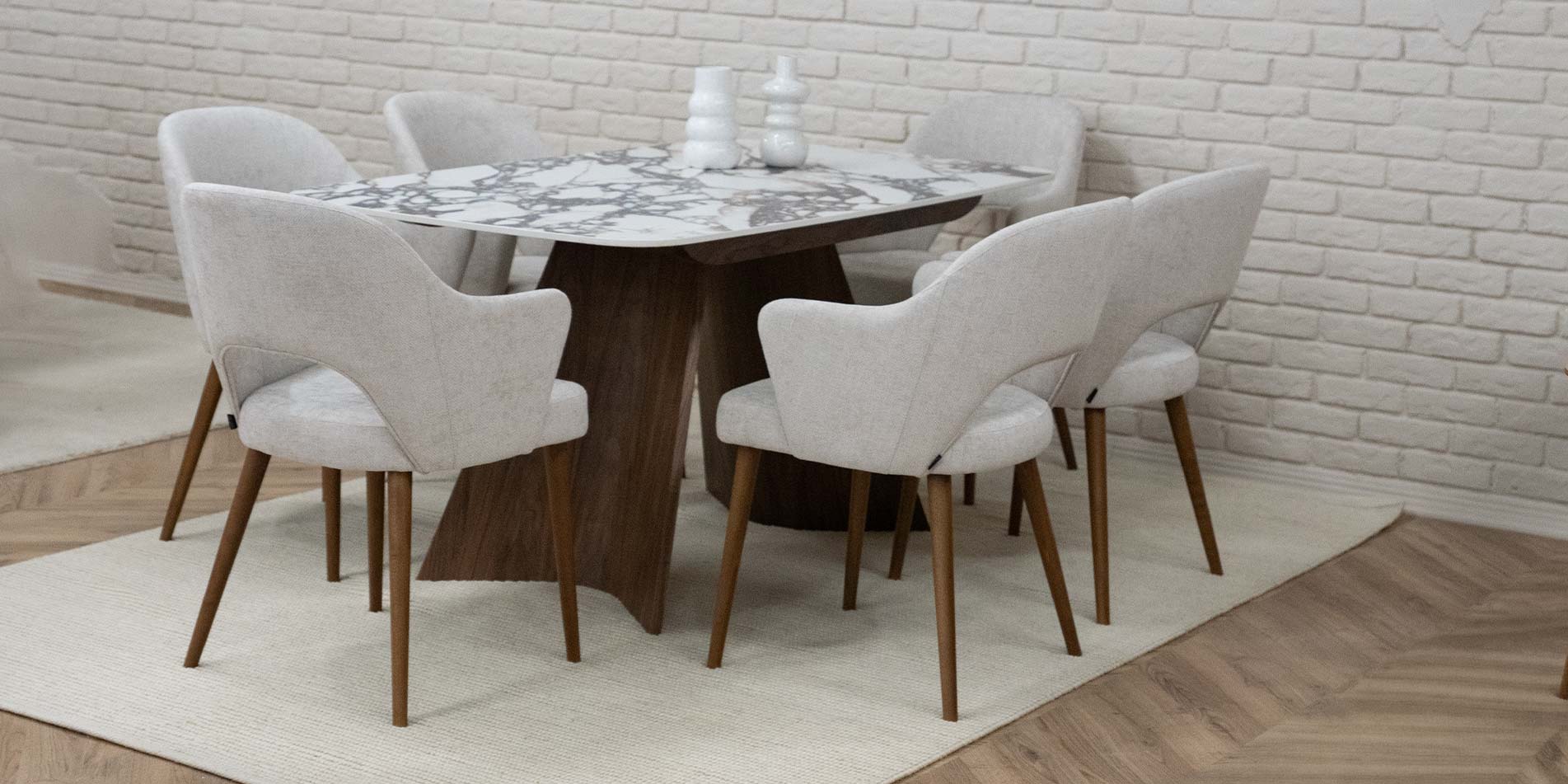 Dining table with ceramic table top in brown and white design, with walnut wood legs. With armchairs with white upholstery. 