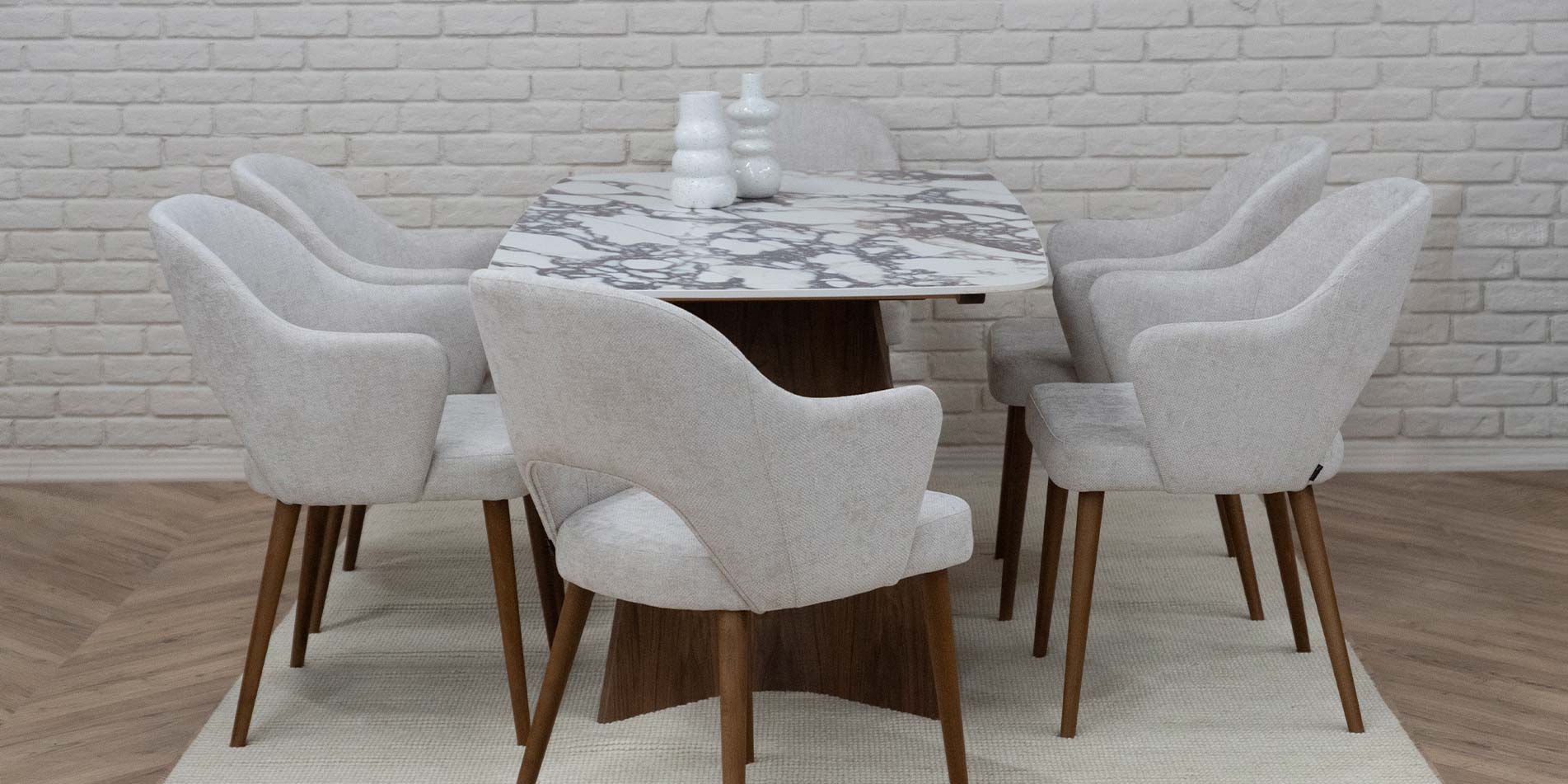 Dining table with ceramic table top in brown and white design, with walnut wood legs. With armchairs with white upholstery. 