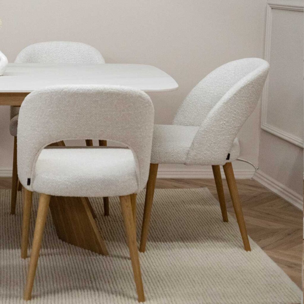 Trpezariska masa Orbis so plotna Laminam vo bela boja i nepravilna forma nogarki od dab, so stolici Aurora so dab nogarki i bel mebel stof.